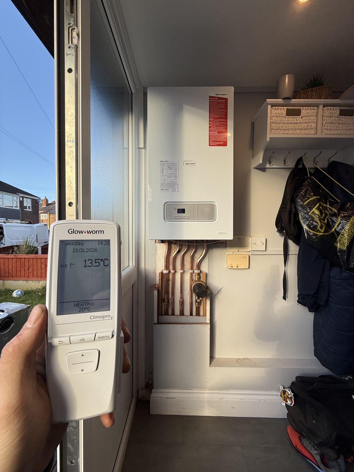 Smart heating controller in hand after a boiler installation